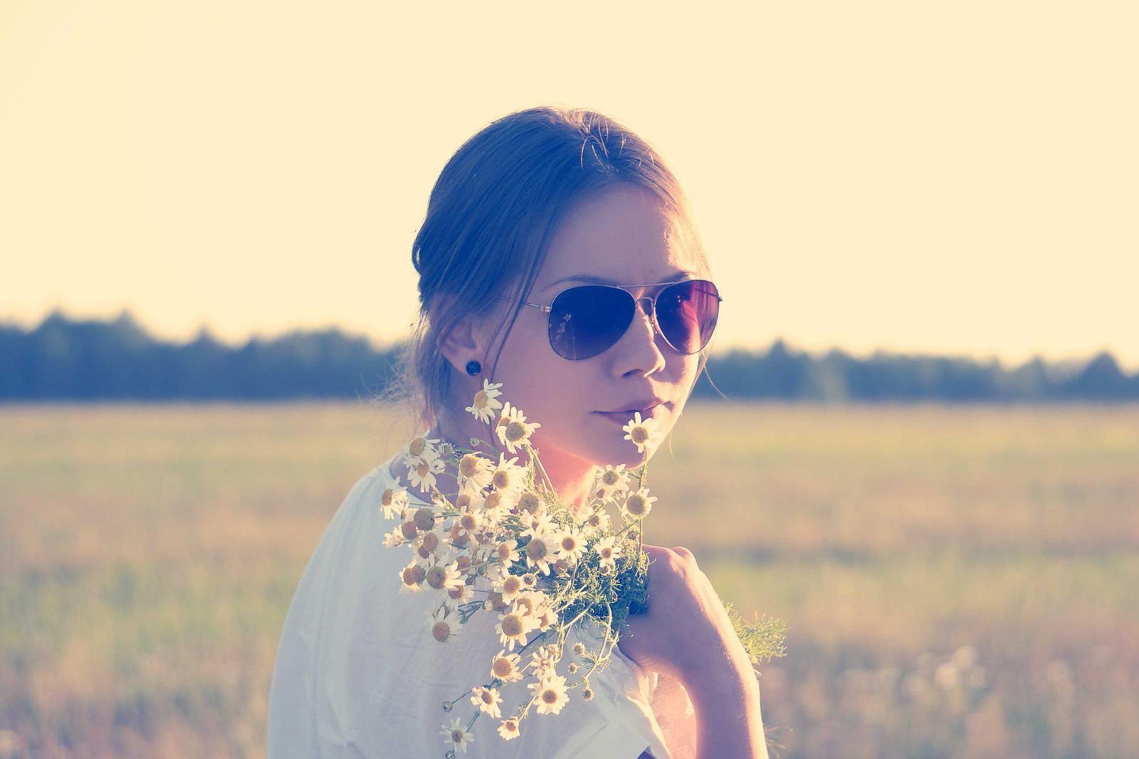 Portrait d'une jeune femme au soleil, fleurs à la main