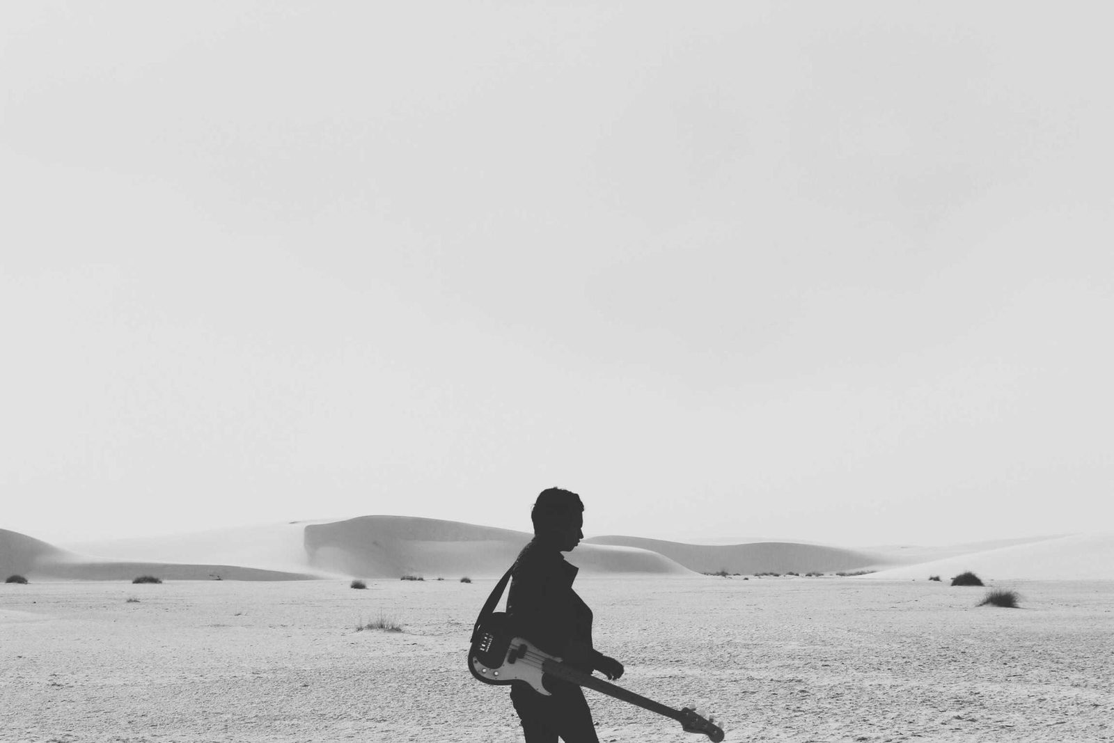 Silhouette marchant seule dans une étendue de sable